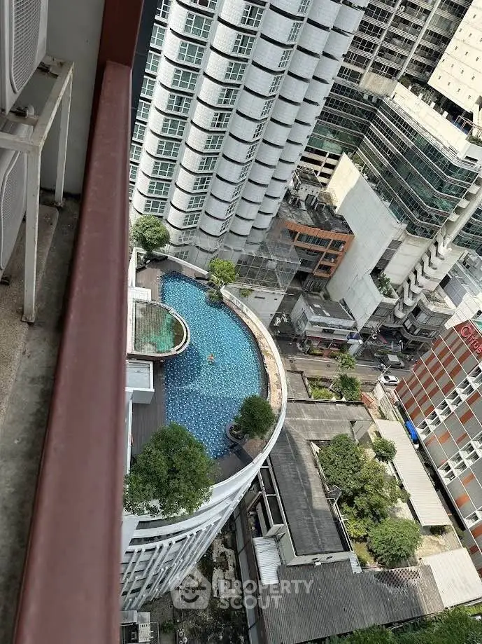 Stunning aerial view of urban high-rise buildings with a luxurious rooftop pool, perfect for city living.