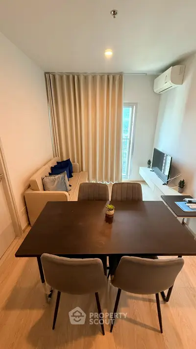 Modern living room with dining area, cozy sofa, and flat-screen TV, perfect for urban living.