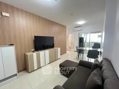 Modern living room with sleek furniture and open dining area, perfect for contemporary living.