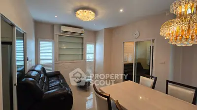 Elegant living room with modern chandelier and leather sofa