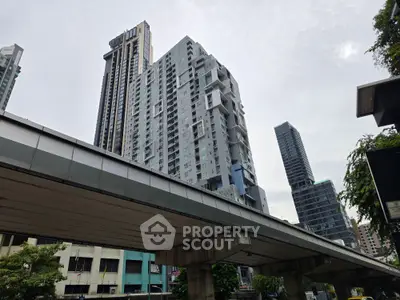 Modern high-rise building with urban skyline view, showcasing contemporary architecture and city living.