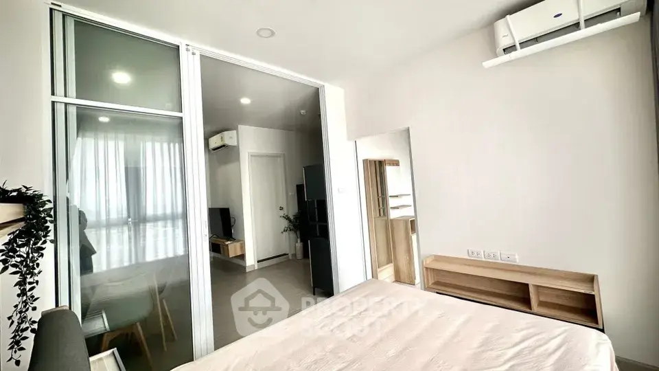 Modern bedroom with sliding glass doors and air conditioning in a stylish apartment.
