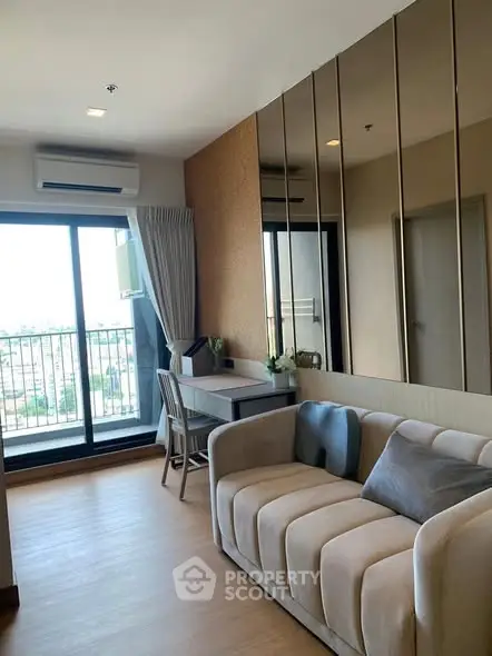 Modern living room with balcony view, featuring stylish sofa and sleek decor.