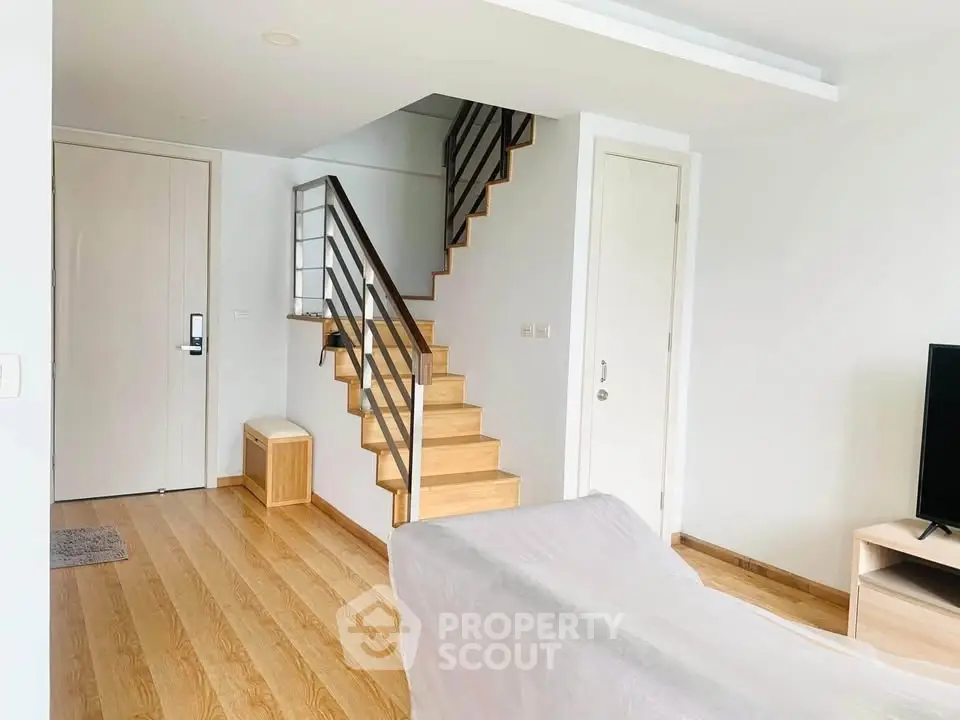 Modern living room with wooden staircase and minimalist decor
