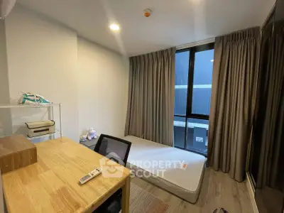 Cozy minimalist bedroom with large window and wooden desk, perfect for a serene living space.