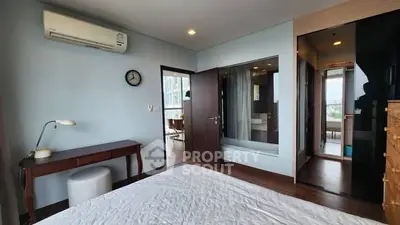 Spacious bedroom with modern decor and air conditioning, featuring a view into the bathroom.