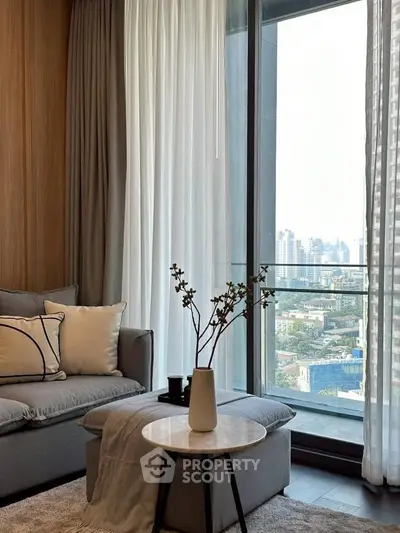 Modern living room with city view, elegant decor, and floor-to-ceiling windows.