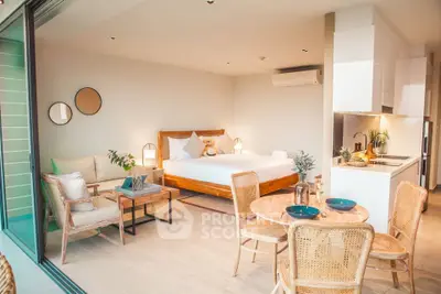 Luxurious open-plan bedroom with modern kitchen and cozy seating area