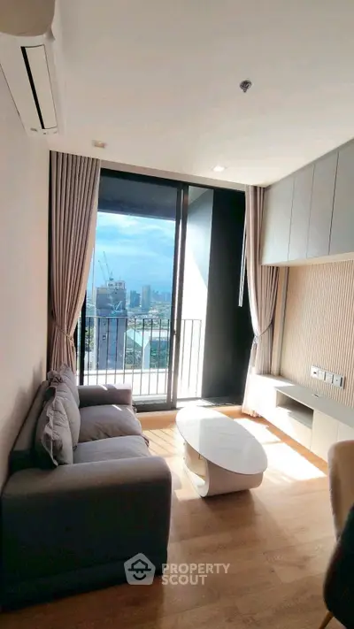 Modern living room with large window and city view, featuring sleek furniture and elegant design.