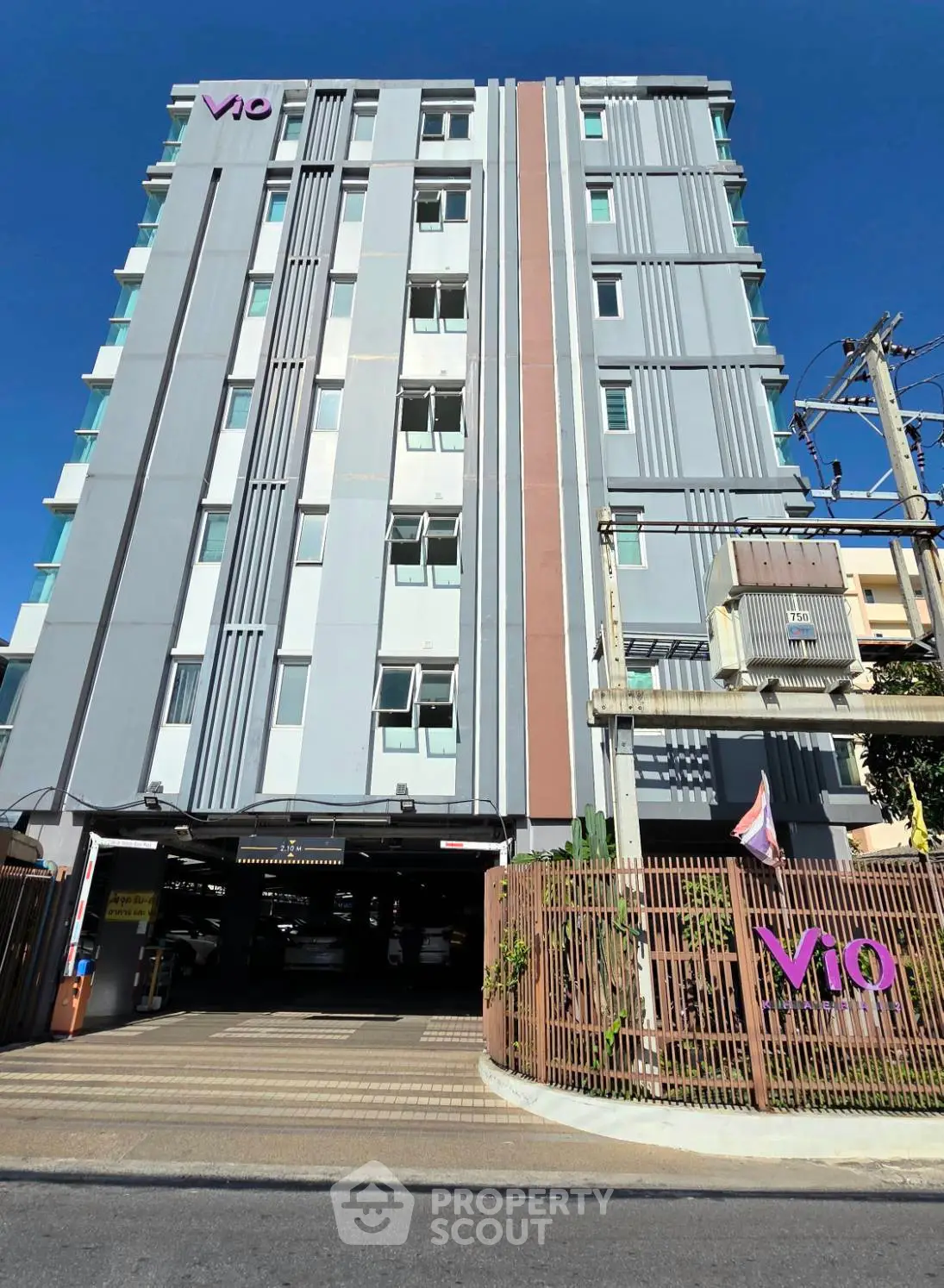 Modern high-rise building with sleek facade and gated entrance, perfect for urban living.