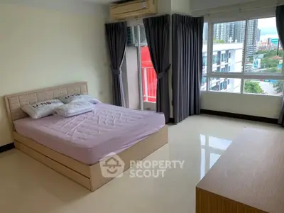 Spacious bedroom with large windows and city view in modern apartment