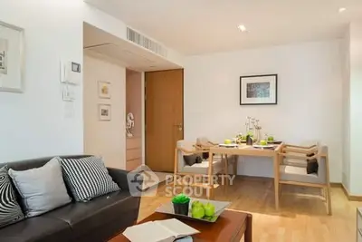 Modern living room with dining area, wooden flooring, and stylish decor