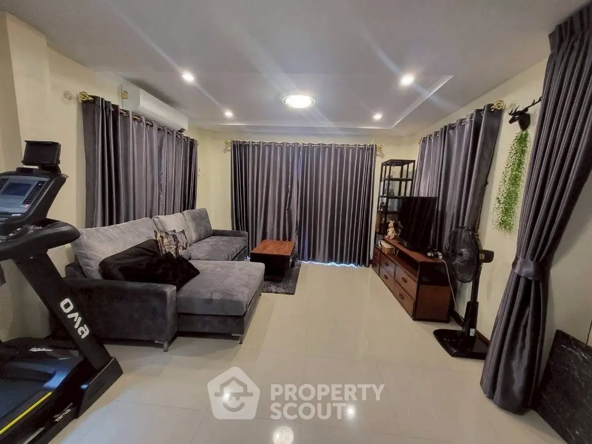 Spacious living room with modern decor and exercise equipment, ideal for relaxation and fitness.