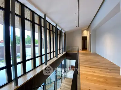 Stunning modern hallway with floor-to-ceiling windows and sleek wooden flooring.