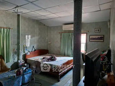 Spacious bedroom with tiled walls, air conditioning, and natural light.