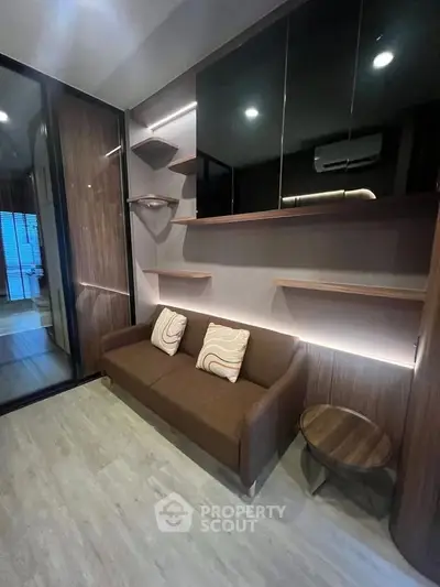 Modern living room with sleek design, featuring a cozy brown sofa, stylish shelves, and elegant lighting.