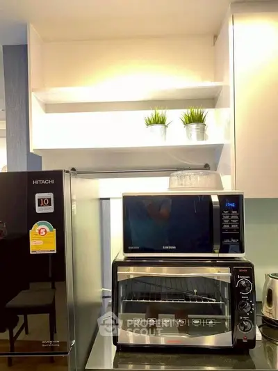 Modern kitchen with sleek appliances including a Hitachi fridge and Samsung microwave, perfect for culinary enthusiasts.