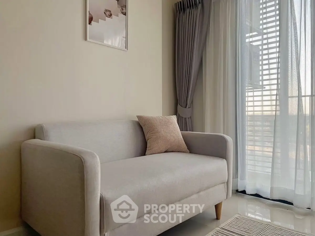 Modern living room with cozy gray sofa and elegant curtains, offering a serene ambiance and natural light.