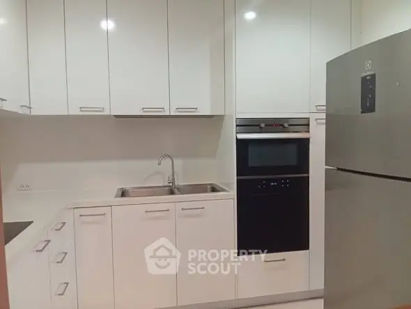 Modern kitchen with sleek white cabinetry and built-in appliances