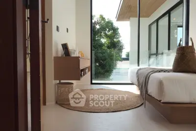 Modern bedroom with large window and minimalist decor, featuring a cozy bed and natural light.