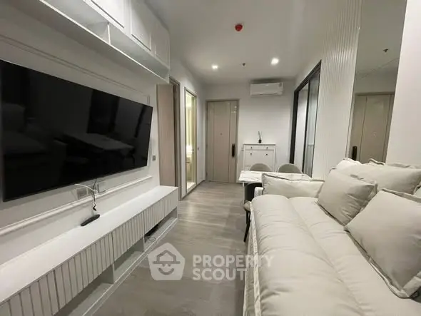 Modern living room with sleek design, featuring a large TV and comfortable seating, perfect for relaxation.