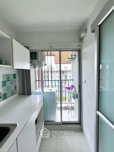 Modern kitchen with balcony view and sleek white cabinetry