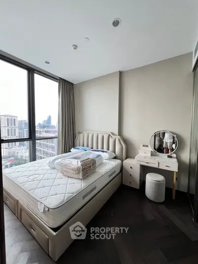 Luxurious bedroom with city view, featuring elegant furniture and large windows for natural light.
