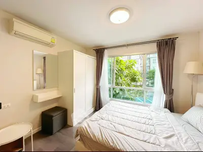 Bright and cozy bedroom with large window and modern furnishings in a stylish apartment.