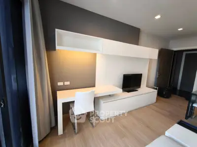 Modern living room with sleek white furniture and built-in TV unit