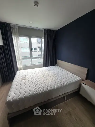 Modern bedroom with large window and stylish dark accent wall