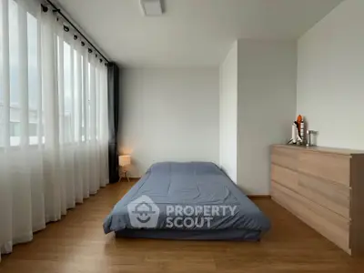 Minimalist bedroom with large window and wooden flooring