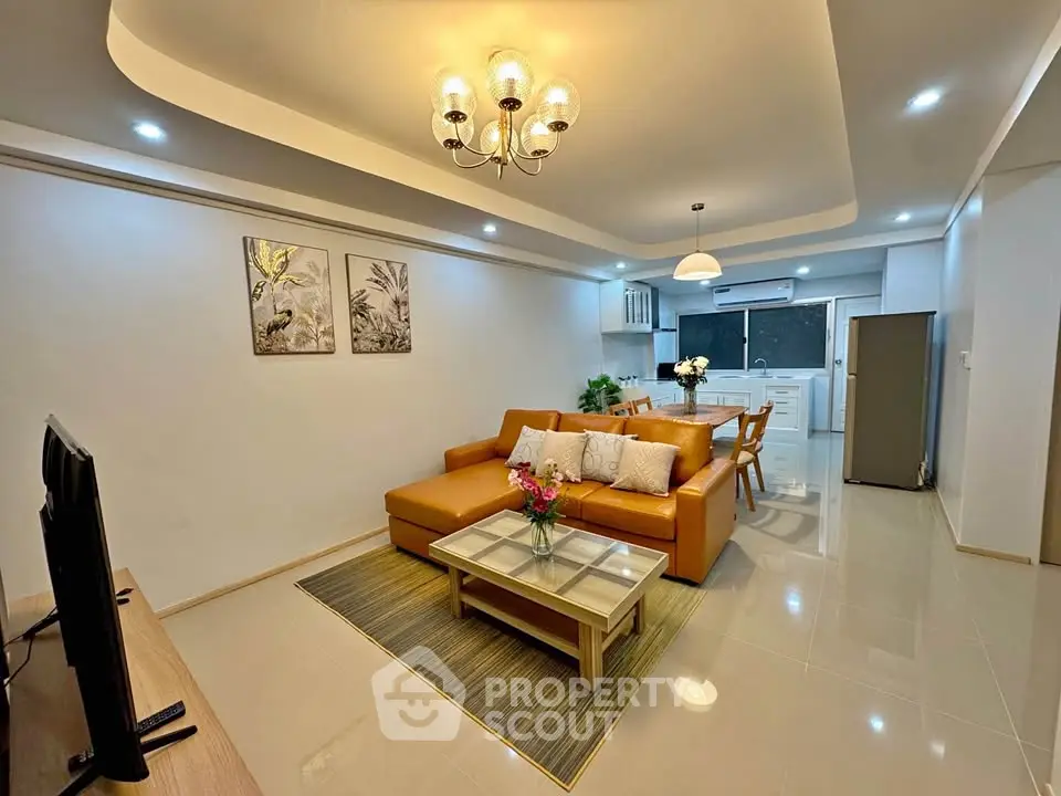 Spacious modern living room with elegant lighting and open kitchen layout