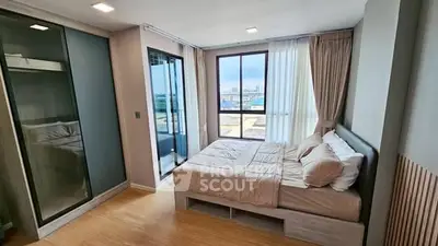 Modern bedroom with large windows and balcony access in a stylish apartment.