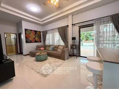 Spacious living room with modern decor and natural light, featuring a cozy sofa and stylish accents.