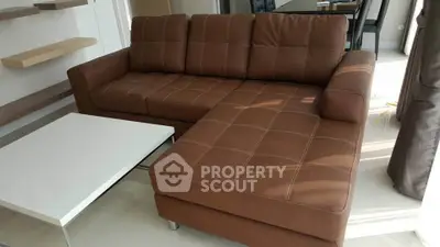 Modern living room with stylish brown sectional sofa and sleek white coffee table.