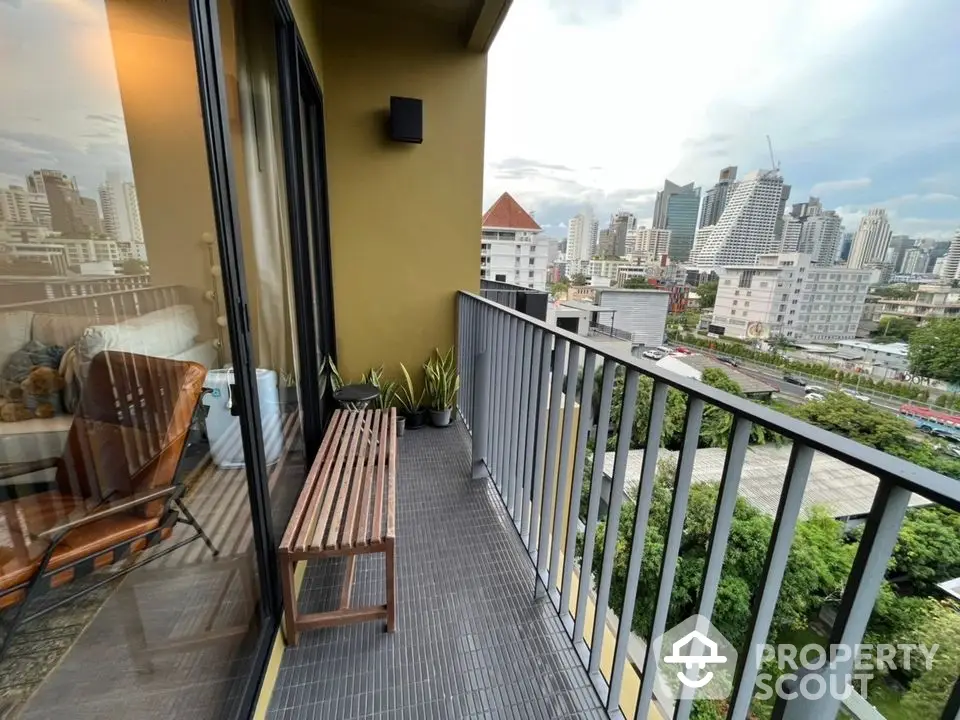 Modern balcony with city view, stylish seating, and lush greenery for urban living.