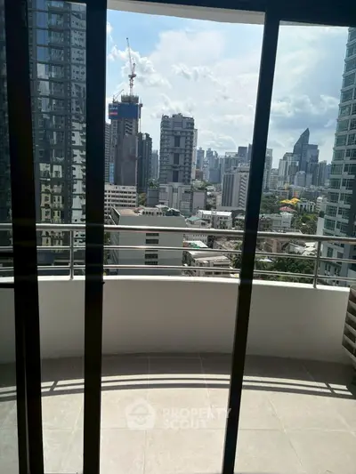 Spacious balcony with stunning city skyline view in modern high-rise apartment.