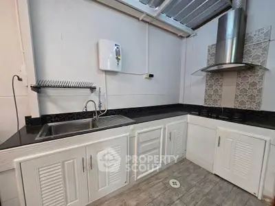 Modern kitchen with sleek cabinetry and gas stove, featuring a stylish backsplash and ample counter space.