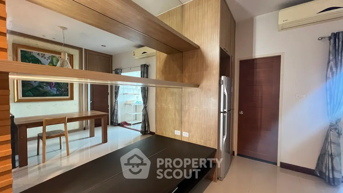 Modern apartment interior with sleek wooden finishes and stainless steel fridge
