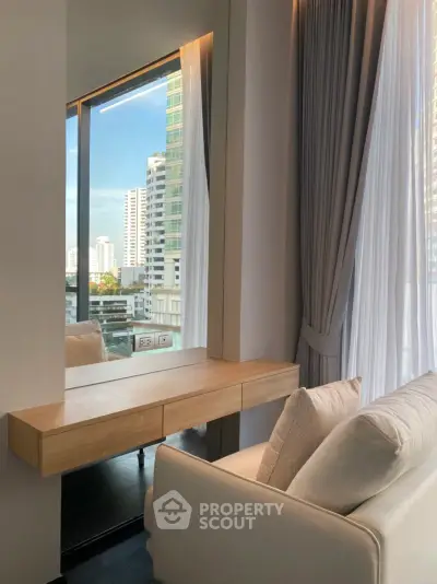 Modern living room with large window and city view, featuring elegant curtains and a stylish console table.