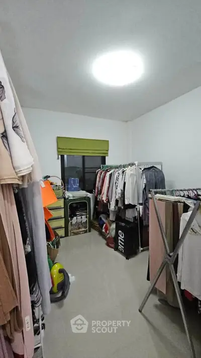 Spacious storage room with ample clothing racks and natural light