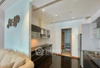 Modern kitchen with sleek black countertops and open shelving in a stylish apartment.