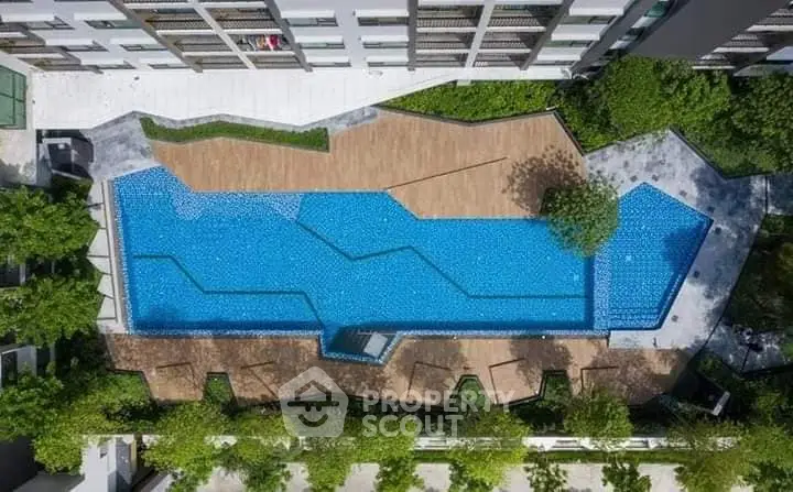 Stunning aerial view of modern apartment complex with luxurious swimming pool and lush greenery.