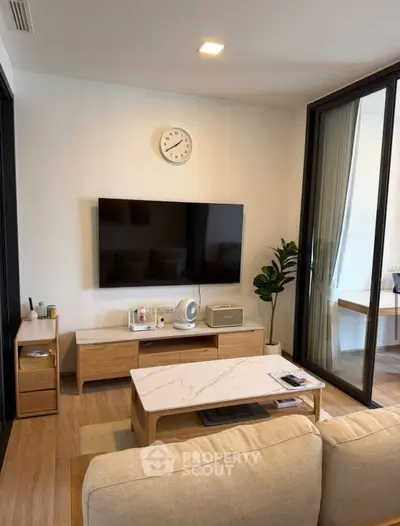 Modern living room with stylish furniture and wall-mounted TV, featuring a cozy ambiance and elegant decor.