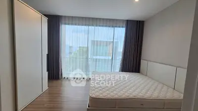 Spacious bedroom with large window and modern wardrobe, perfect for natural light lovers.