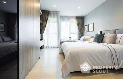 Spacious modern bedroom with large bed, elegant furnishings, and abundant natural light filtering through sheer curtains, perfect for relaxation.