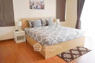 Spacious bedroom with stylish decor and natural light, featuring a comfortable bed and elegant furnishings.