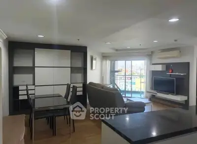 Spacious modern living room with balcony and city view, featuring sleek furniture and open layout.