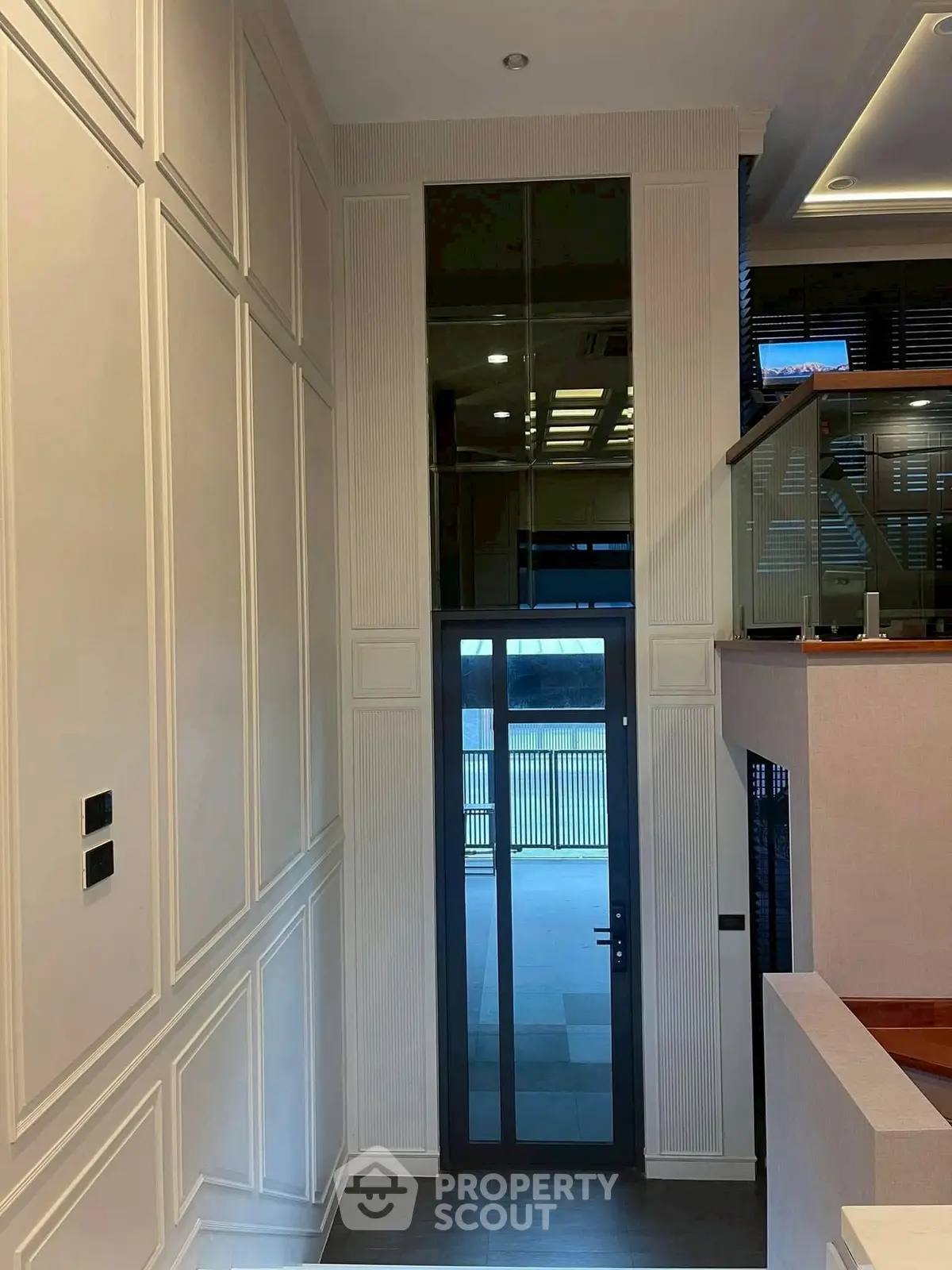 Elegant modern interior with high ceilings and glass door entryway