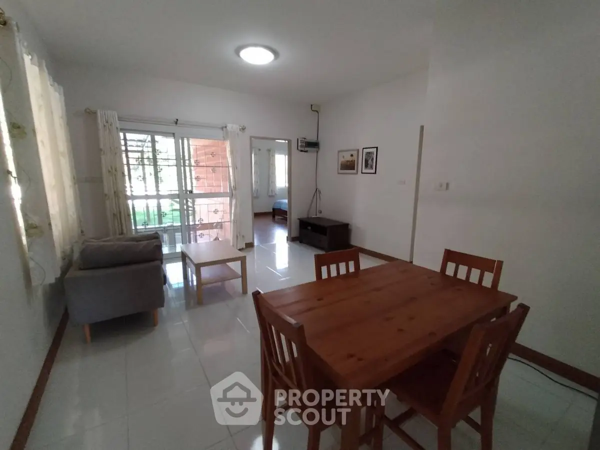 Spacious living room with dining area and natural light, perfect for family gatherings.